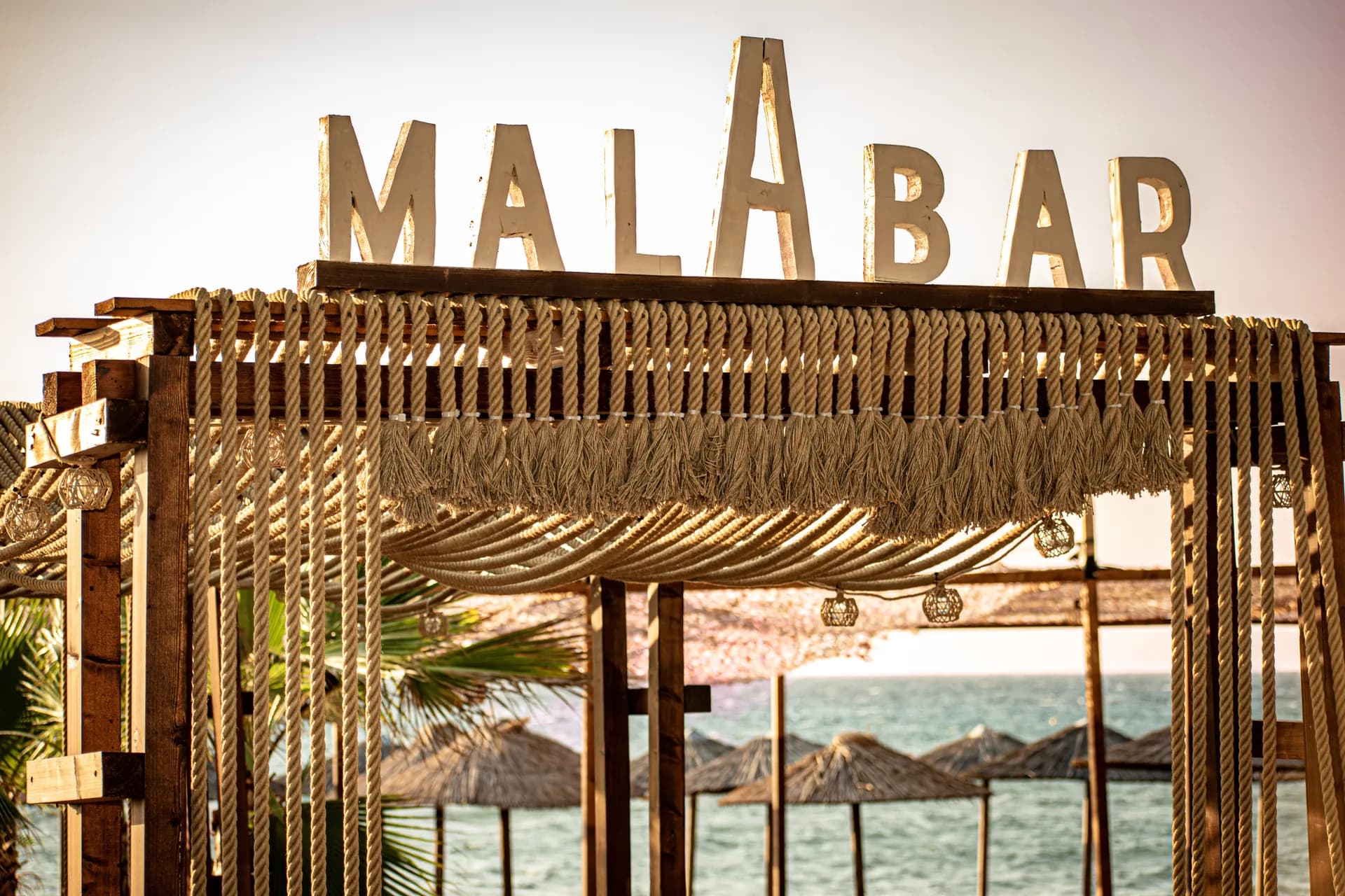 Η ξύλινη επιγραφή Malabar με σχοινιά και θέα στη θάλασσα